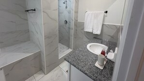 A modern bathroom with a shower, a sink, and a toilet. - BRAND NEW Austin Estates #3 2bed/2bath Apartment (Nassau)