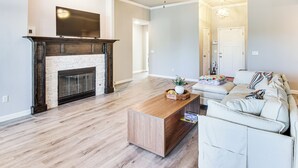 Un salon spacieux doté d’une cheminée, d’un ventilateur de plafond et d’un canapé.