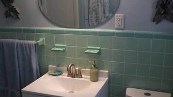 Chuveiro, toalhas de banho, sabonete, papel higiênico