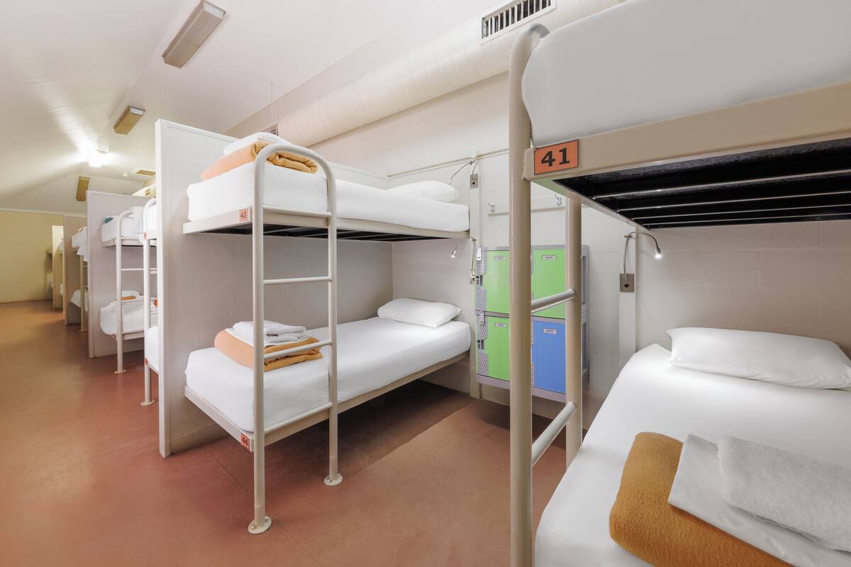 A dormitory room with bunk beds, numbered room 41, and a green storage cabinet.