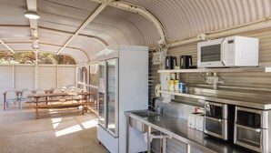 A kitchen with stainless steel appliances, a refrigerator, and a sink. - Outback Lodge (Ayers Rock)
