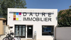 A real estate agency named DAURE IMMOBILIER with a white facade, a glass door entrance, and a row of bicycles parked outside. - Lovely corner house,well equipped for 5 people, Airco upstairs, in a secured residence LE VILLAGE... (PORTIRAGNES)