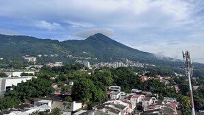 Un pueblo con edificios y una montaña al fondo.