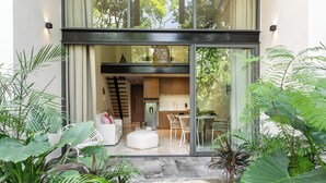 Een modern interieur met een eethoek, keuken en woonruimte, zichtbaar door grote glazen deuren.