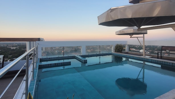 A rooftop infinity pool with a clear view of the city skyline and a moon in the sky. - Mirador del Cielo  (Santa Cruz)