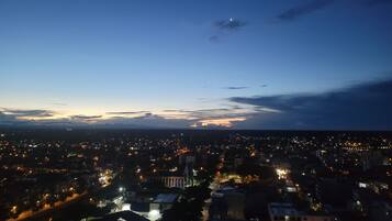 Un paisaje urbano al atardecer con una luna creciente en el cielo.