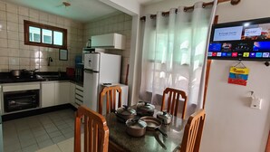 Une cuisine équipée d’un réfrigérateur, d’une cuisinière et d’une table à manger avec des chaises.