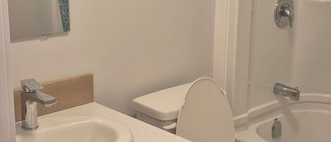 Et badeværelse med vask, toilet og badekar.