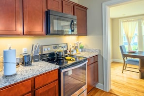 A kitchen with granite countertops, stainless steel appliances, and wooden cabinets.