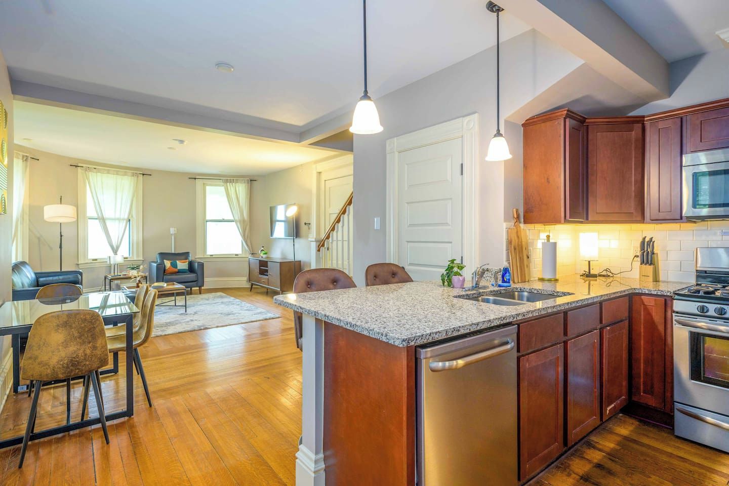 A modern kitchen with granite countertops, stainless steel appliances, and wooden cabinets.