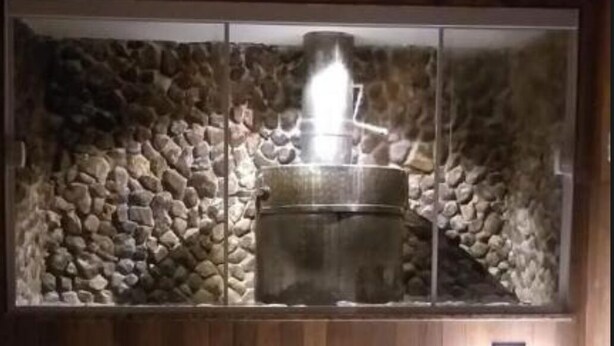 A stone wall with a metal barrel and a lit candle in the center. - Cozy apartment in the Imperial Condominium (Lambari)
