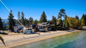 A coastal property with multiple houses, a sandy beach, and clear water. - Lake Tahoe Luxury Lakefront Villa Private Beach luxe9 (South Lake Tahoe)