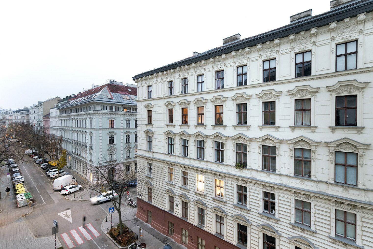 A row of historic buildings with uniform architectural style, featuring multiple windows and a consistent facade design.
