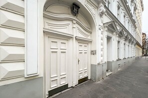 En hvid bygning med en stor buegang og en dør med nummer 10.