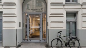 Entrada de um edifício com porta de vidro identificada com 