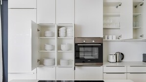 Uma cozinha moderna com armários brancos, forno embutido e fogão.