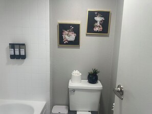 Een haardroger, handdoeken, zeep, toiletpapier