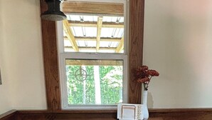 A corner with a wooden bench, a small table, and a window with a view of greenery. - Jasper Short Line
1968 Train Caboose (Jasper)