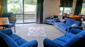 Uma sala de estar com sofás azuis, uma mesa de centro de madeira e um tapete estampado.