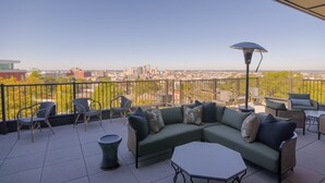 A rooftop terrace with a green sofa, chairs, and a table, overlooking a cityscape. - Funky 1 Bedroom in 5 Points. State of the Art Gym. Long Term Stays Welcome (Birmingham)