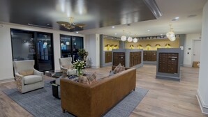 A modern lobby with a sofa, armchairs, and a coffee table. There are lockers in the background and a large window with blinds. - Funky 1 Bedroom in 5 Points. State of the Art Gym. Long Term Stays Welcome (Birmingham)