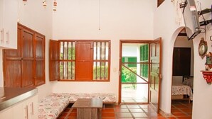 A small, cozy room with a bench, a table, and a door leading outside. - Family cabin in Punta Bolivar, safe condominium near the sea, with parking. (San Antero)