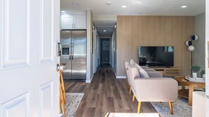 Una sala de estar moderna con sofá, televisor y detalles de madera.