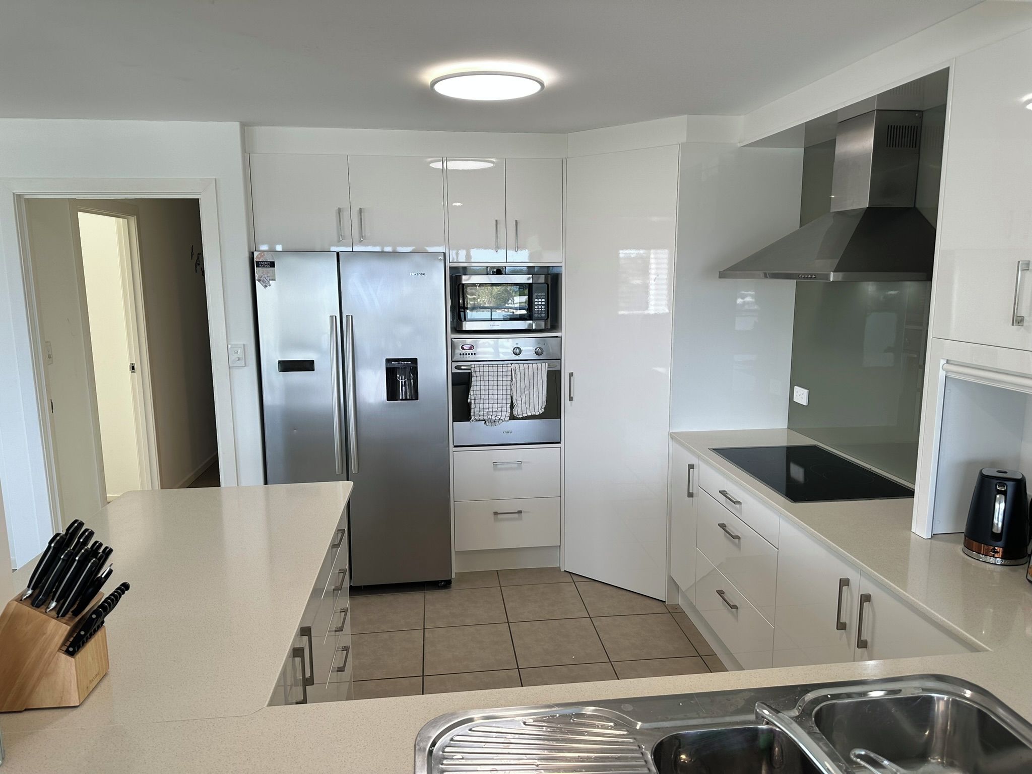 A modern kitchen with stainless steel appliances, a built-in oven, and a large island with a sink.