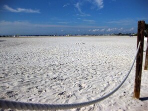 Ein Strand mit einem Holzzaun im Vordergrund.