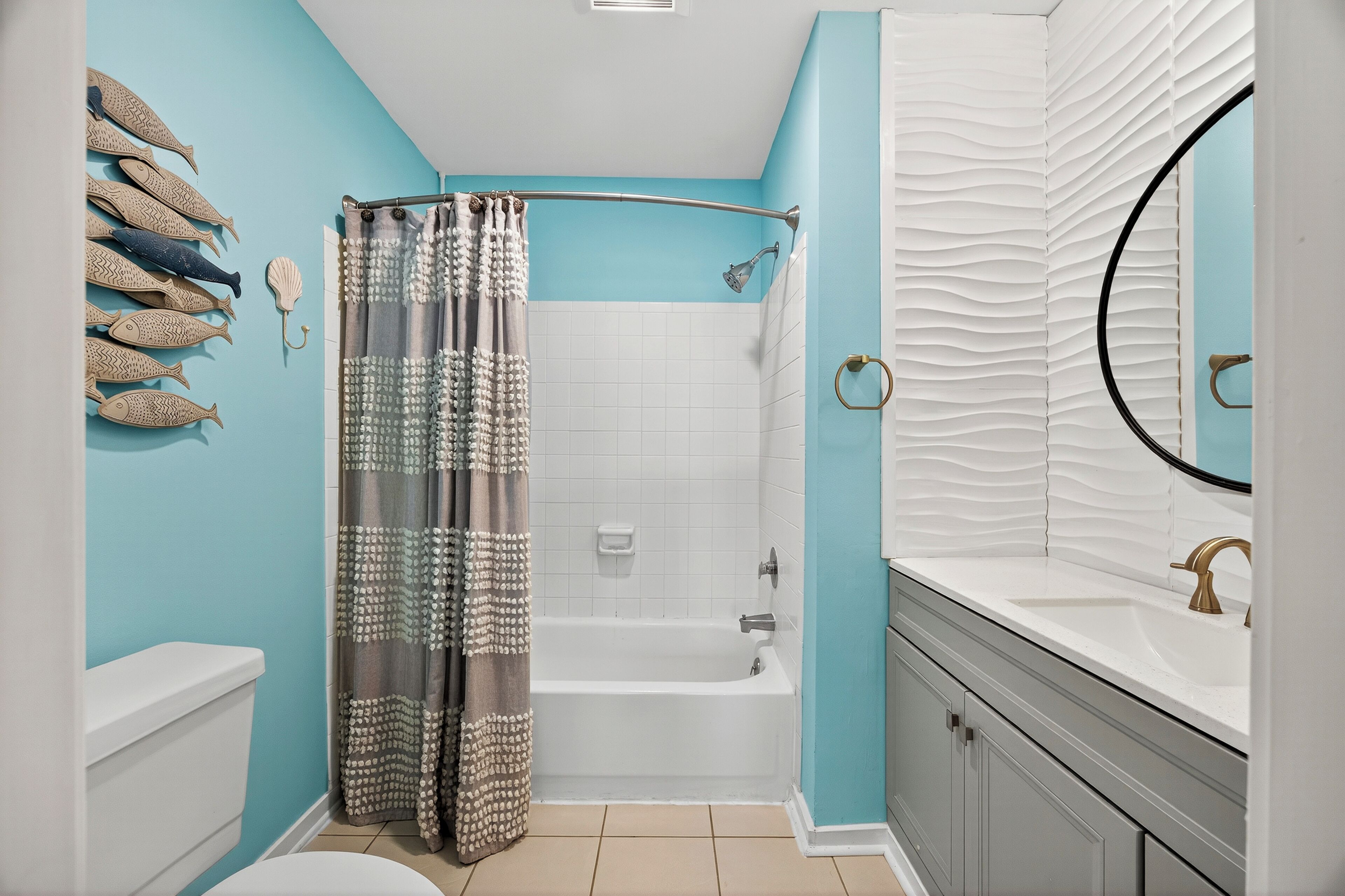 Une salle de bain avec douche, toilettes et lavabo.