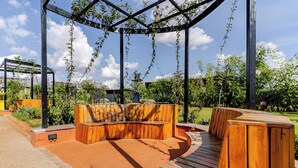 Ein hölzerner Sitzbereich im Freien mit einer Pergola darüber.