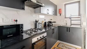 Eine moderne Küche mit Gasherd, Mikrowelle und Edelstahlgeräten.