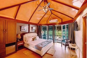 A bedroom with a bed, bedside table, and a ceiling fan.