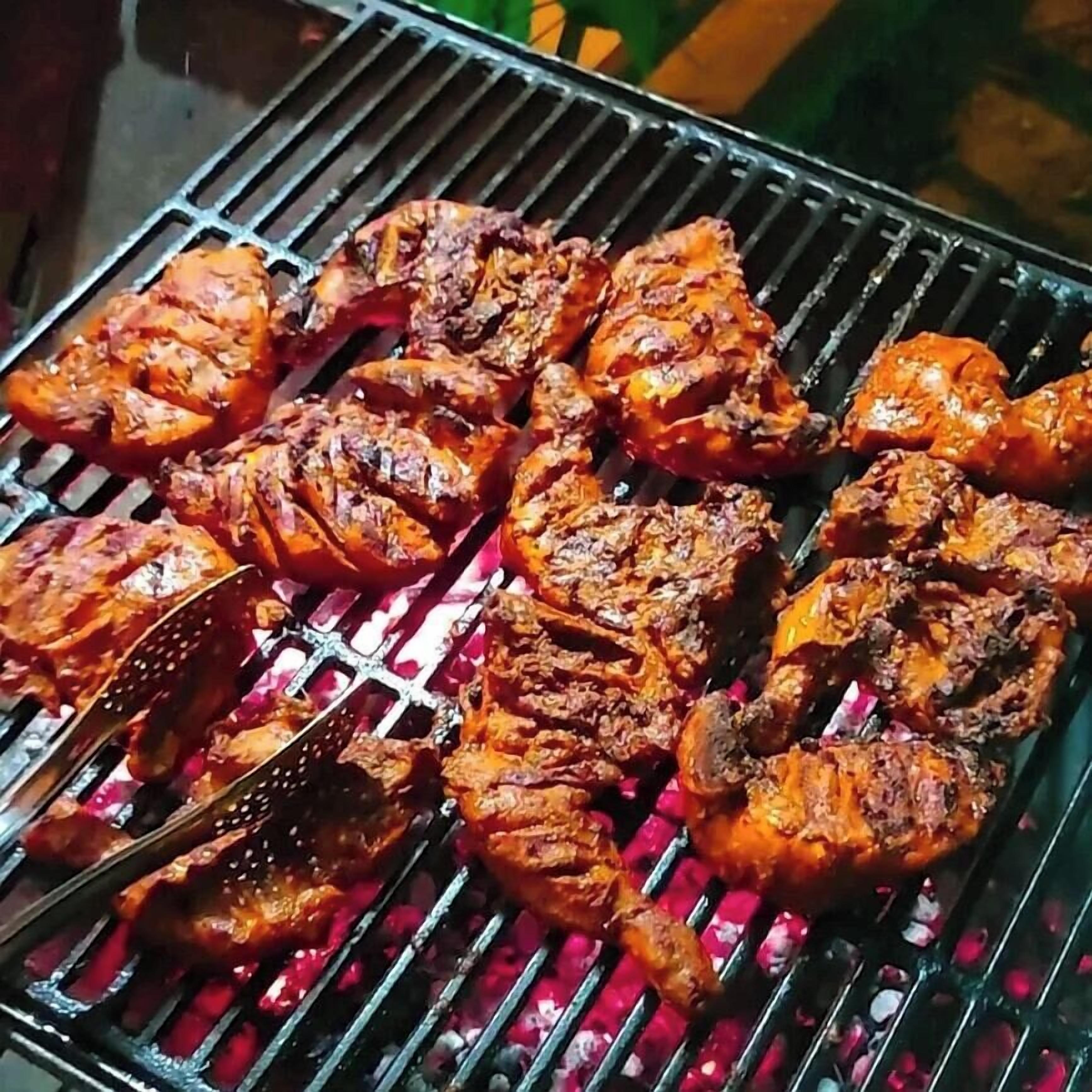 Una parrilla con varios tipos de carne asándose.