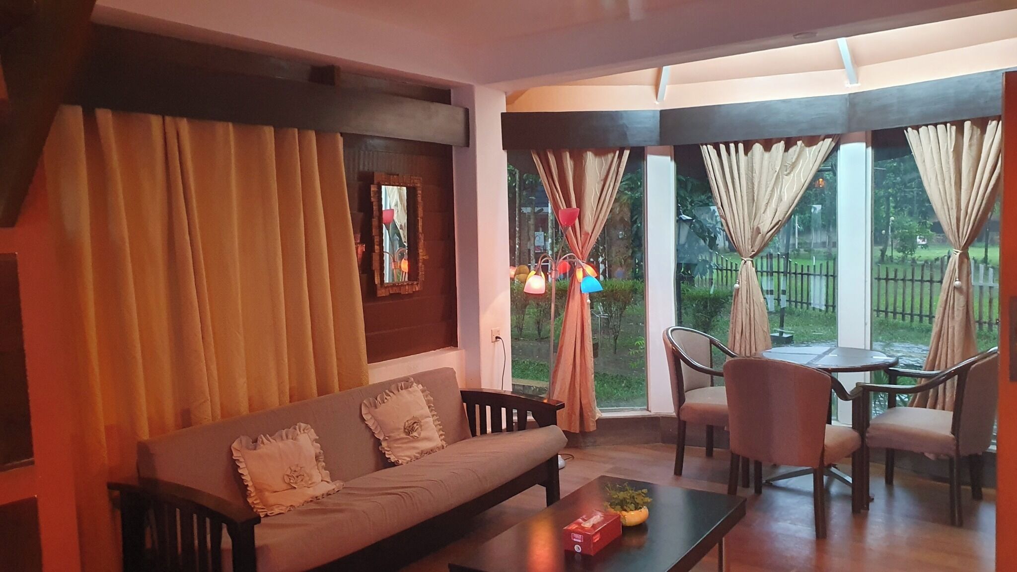 A living room with a sofa, a coffee table, and a dining area with chairs and a table.