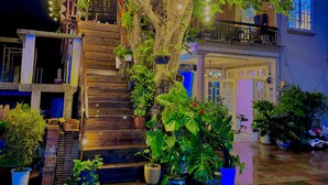 A multi-story building with a wooden staircase leading to a balcony. - My Stay 1 Le Van Tam (Xuan Huong - Da Lat)