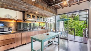 Une cuisine moderne avec des meubles en bois, un four à micro-ondes encastré et un coin repas comprenant une table et des chaises.