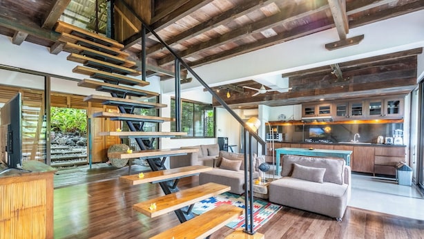 Un intérieur moderne avec un escalier en bois, un canapé et un coin cuisine.