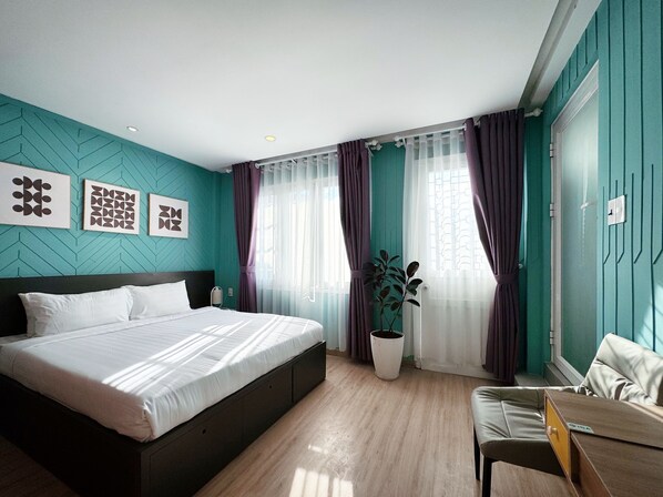 A modern hotel room with a large bed, a desk, and a potted plant. - Your Second Home - 11 Nguyen Van Troi Da Lat (Da Lat)