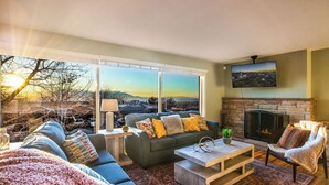 A living room with a sofa, coffee table, and fireplace. - Spacious, Modern 4BR house with city view and easy access to ski resorts (Salt Lake City)