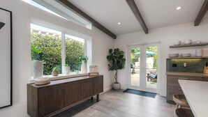 A modern kitchen with a wooden cabinet, large windows, and a view of the outdoors. - Luxury 3-Bed Beach Cottage with Hot Tub, Fire Pit, BBQ - Walk To Beach (Cardiff By The Sea)