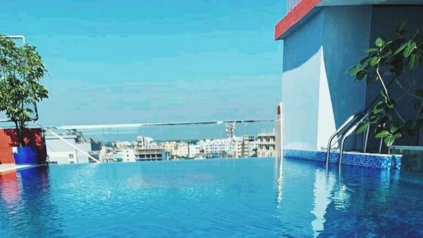 A clear blue pool with a view of buildings in the background. - Annex Suites Bogura (Bogra)