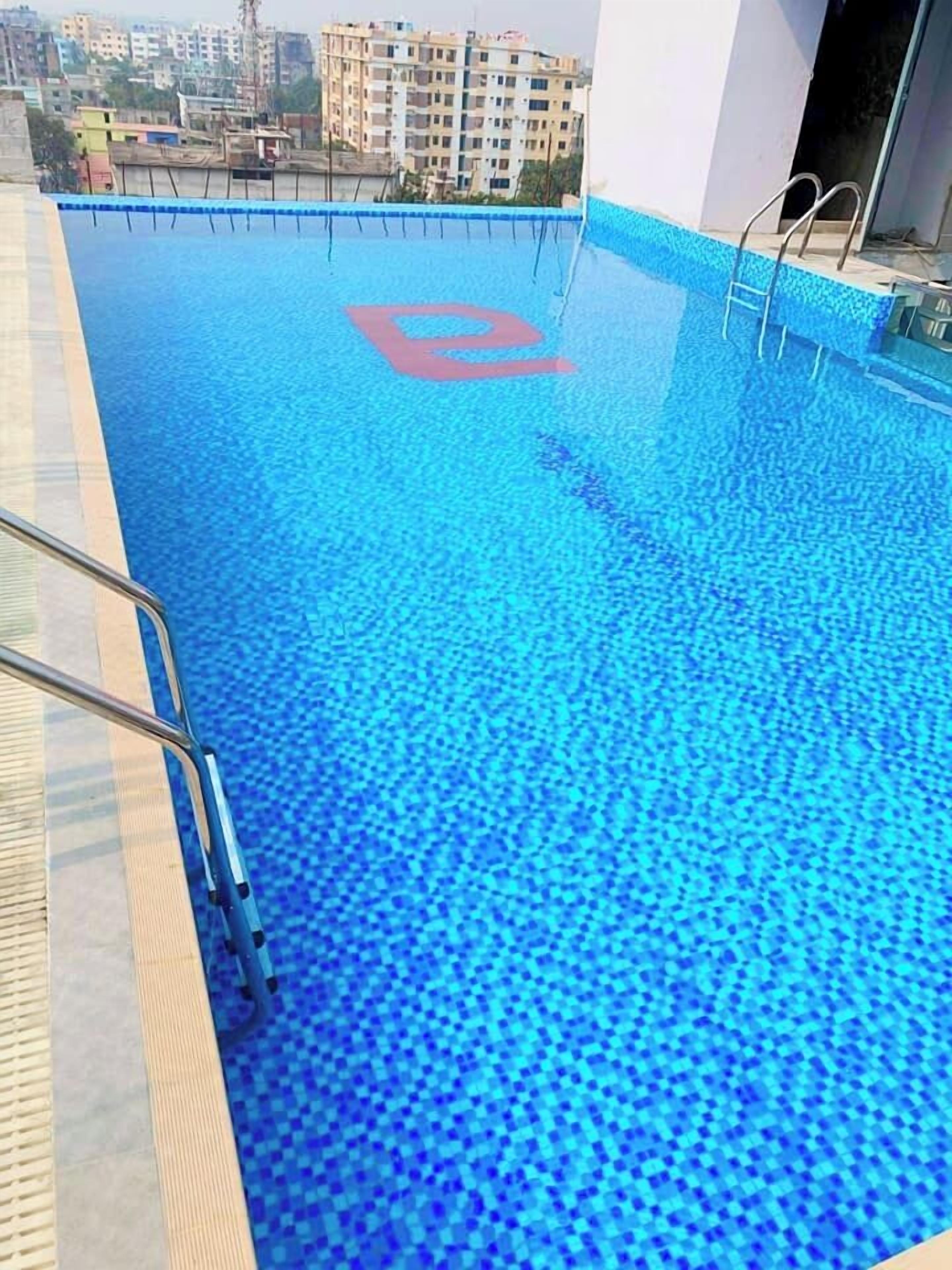 A swimming pool with a blue tiled floor and a red logo in the center.