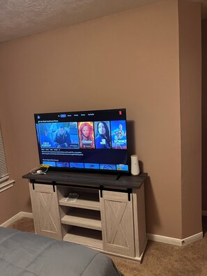 Tabla de planchar con plancha, internet y ropa de cama