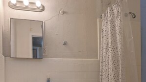 Een badkamer met toilet, wastafel en douchegordijn.