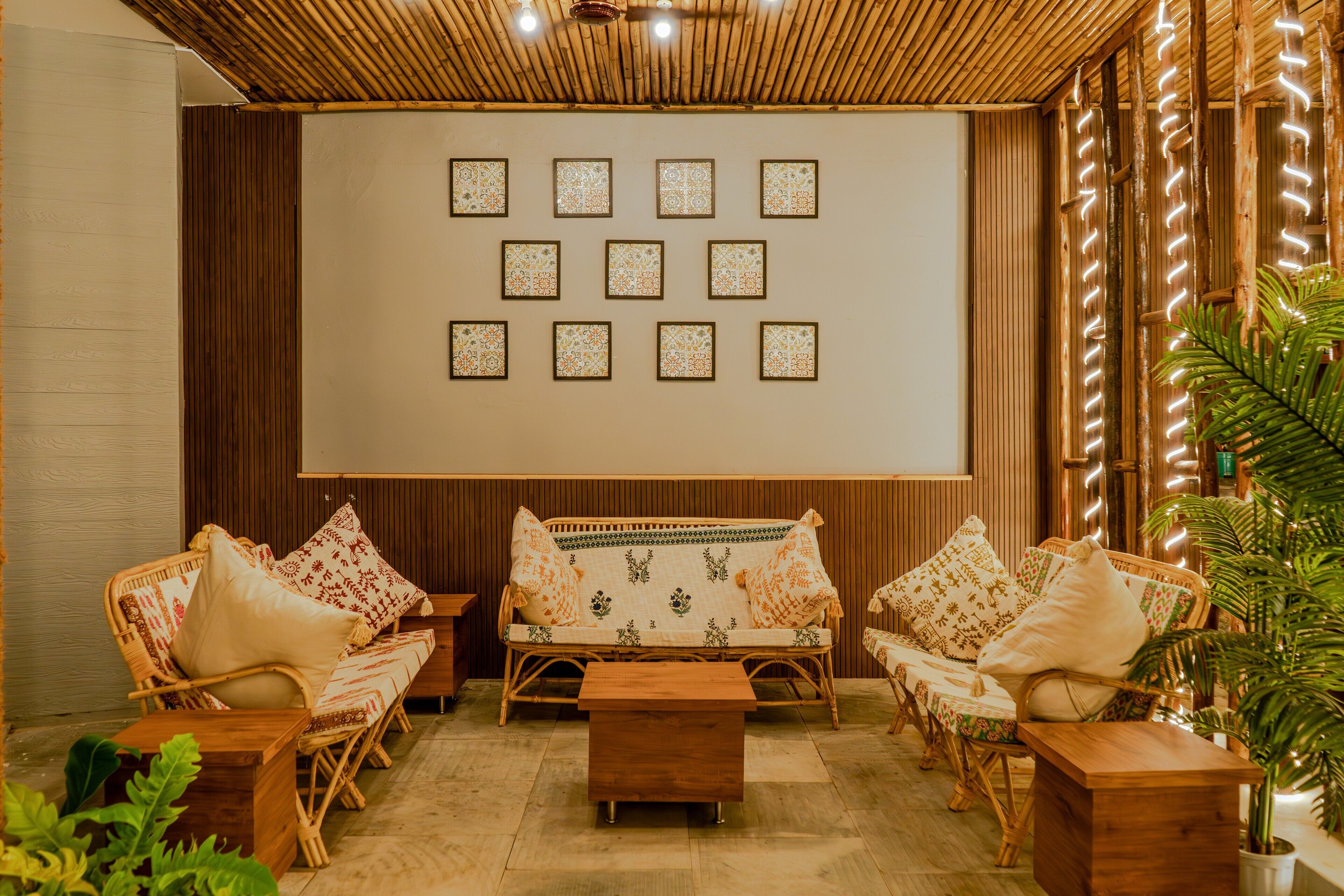 A room with a wooden ceiling, a sofa set, a coffee table, and a wall with framed pictures.