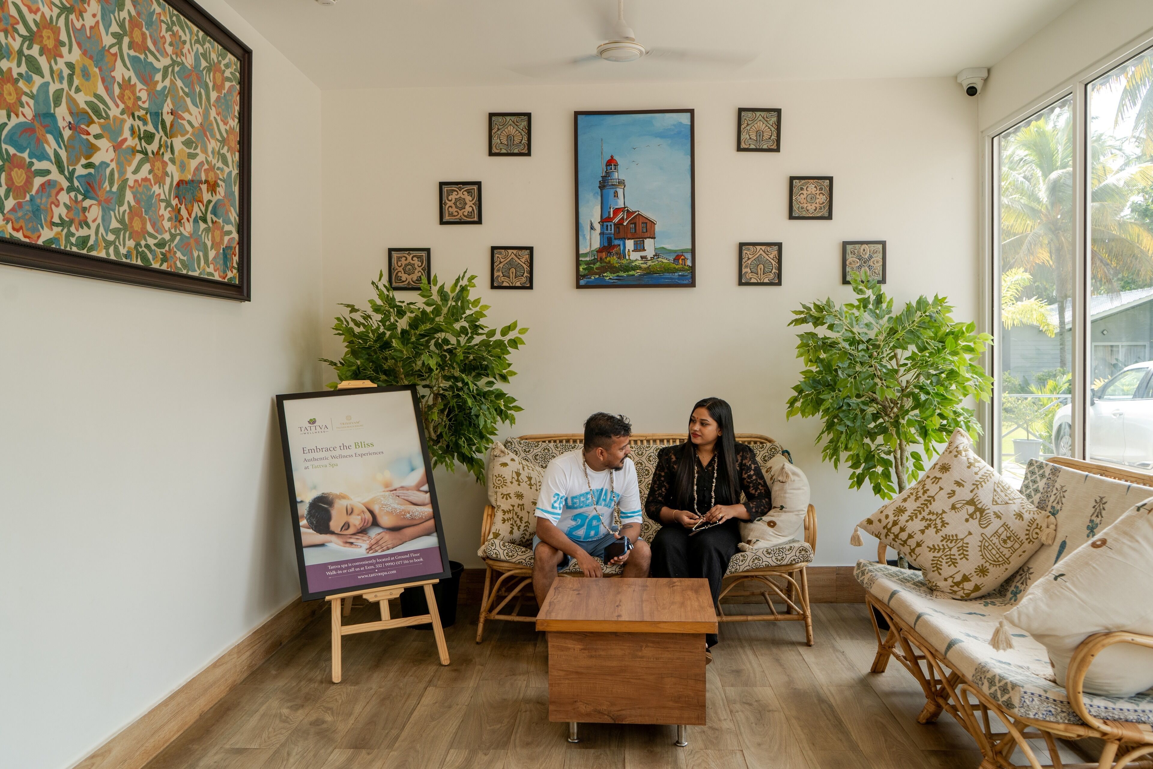 A room with a wooden floor, a sofa, a coffee table, and framed artwork on the walls.