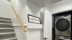 Une buanderie avec une pancarte au-dessus d’une porte indiquant : « LAVAGE, SÉCHAGE ET PLIAGE ».