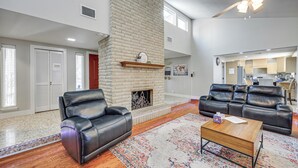 A spacious living room with a fireplace, leather sofas, and a coffee table. - Work, Explore & Unwind: Convenient San Antonio Gem (San Antonio)