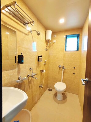 A bathroom with a toilet, sink, and shower. - Great Samrat Residency (Khopoli)